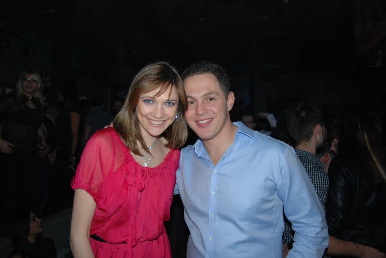 the young couple smiles at the camera at the party