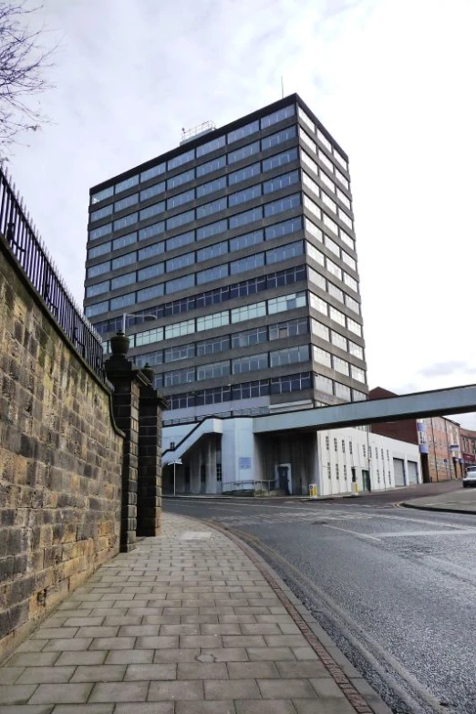 there is a stone wall and a very tall building