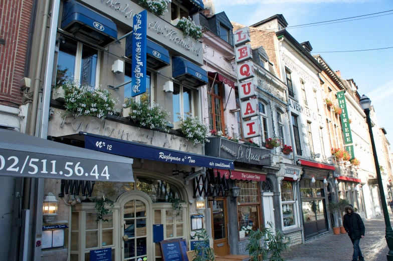 many shops on a city street with a person walking near them