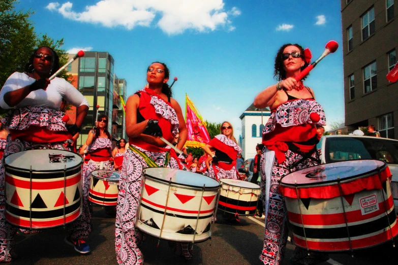 some people are performing and drumming in the street