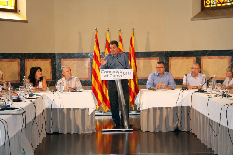 many people sitting at a table with flags at different places