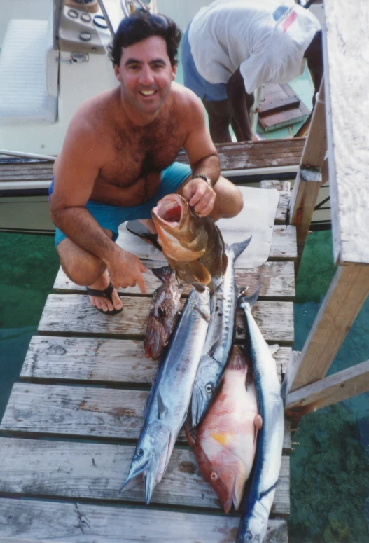 a man holding up some fish on a boat