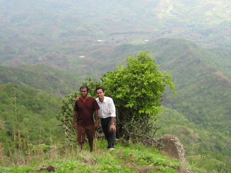 two men are standing on a small hill