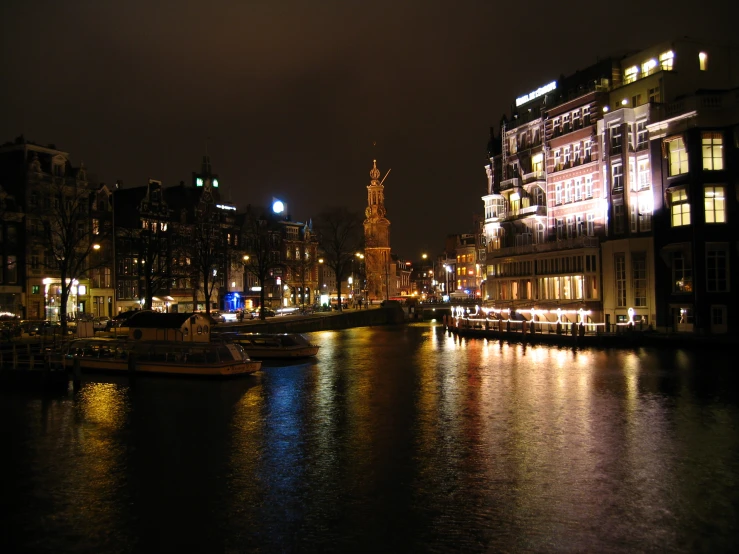 a city by the water at night with lights reflecting off the water