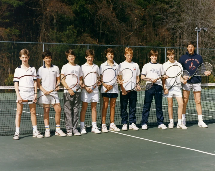 a large group of young people holding tennis rackets