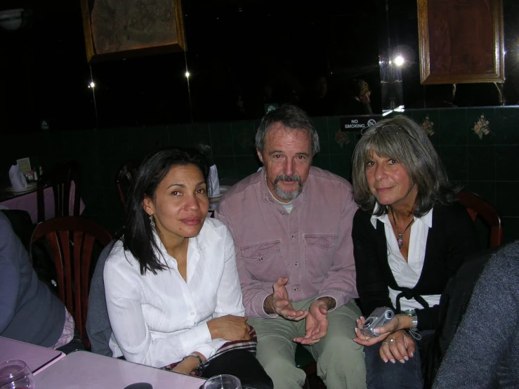 four people sitting at a table and one person looking at the camera