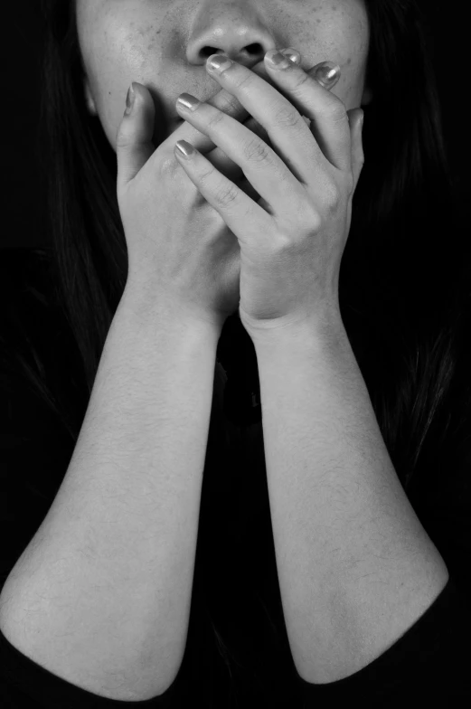 a woman with her hands covering her mouth