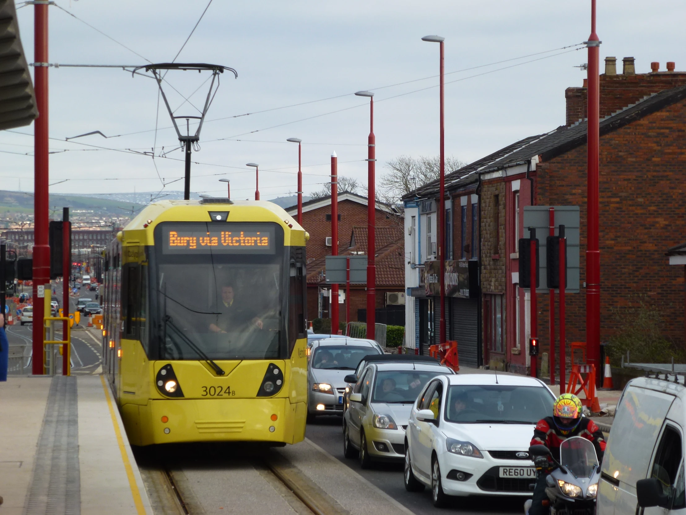 a yellow bus is driving in traffic behind cars