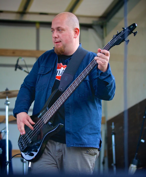 a man playing an electric bass guitar in a room