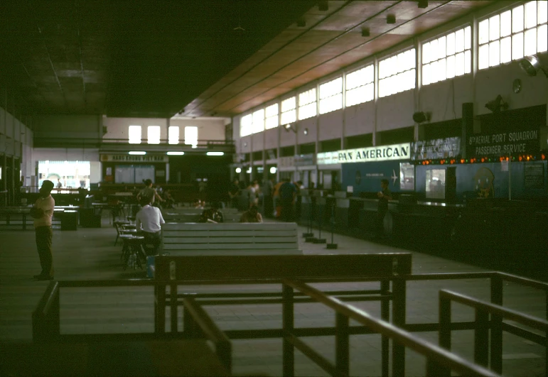 people walking and sitting in a terminal at night