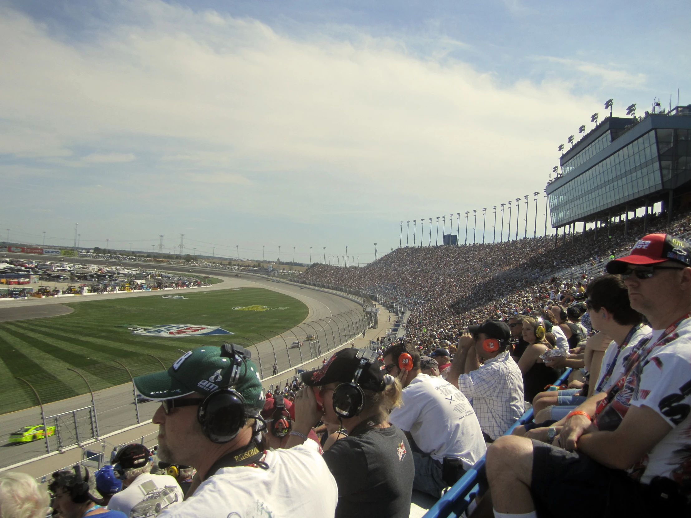 a crowd watches as the driver and car drive by