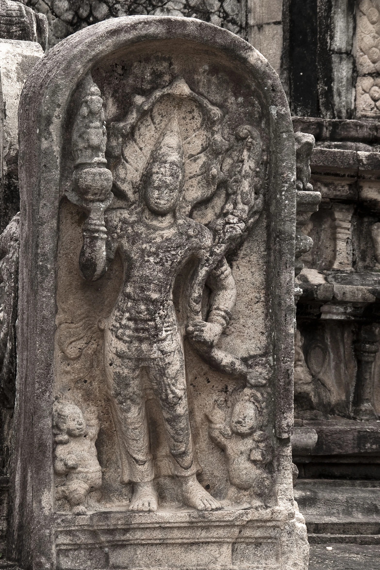 a stone statue at the top of an old building