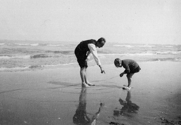 an adult and child are playing in the water at the beach