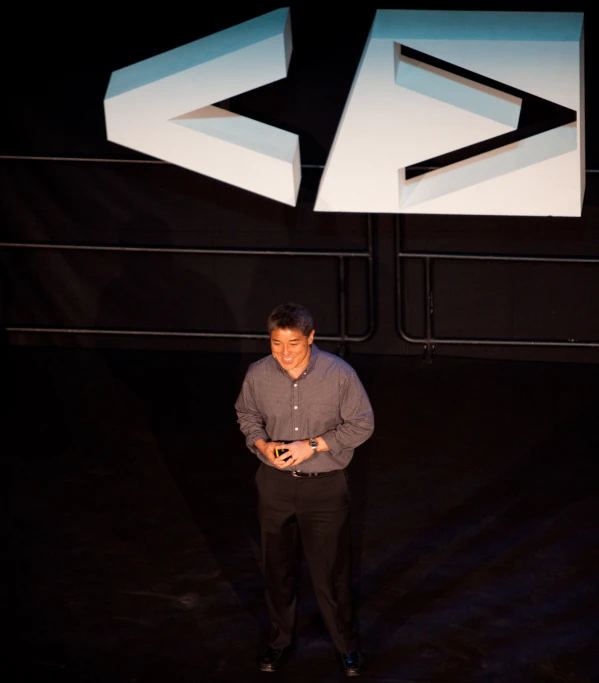 a man standing in front of a sign holding a cell phone