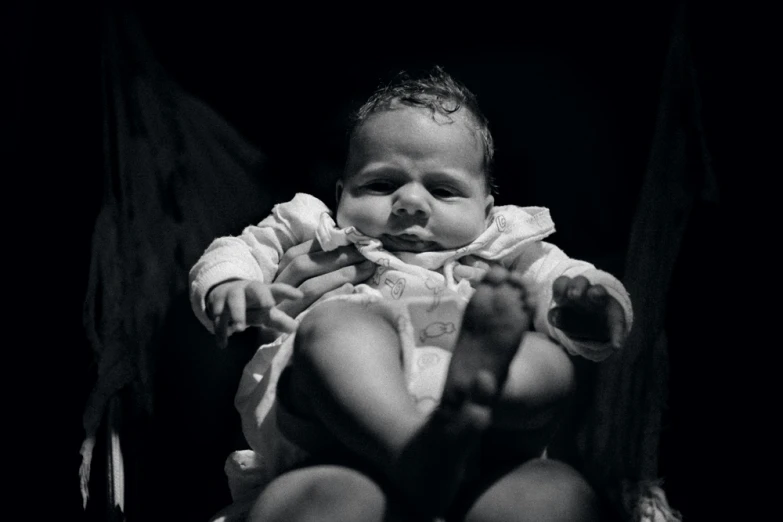 a black and white po of a baby sitting on a chair