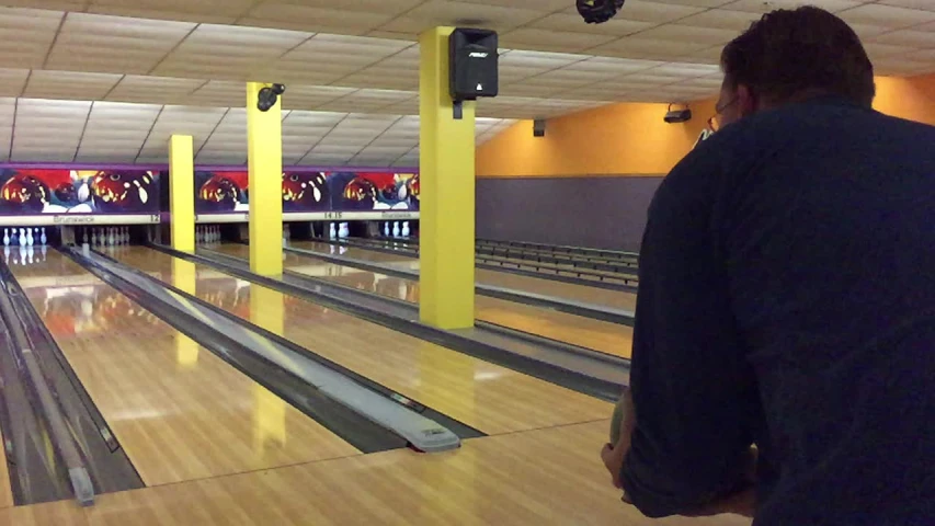 a man standing in front of a bowling alley