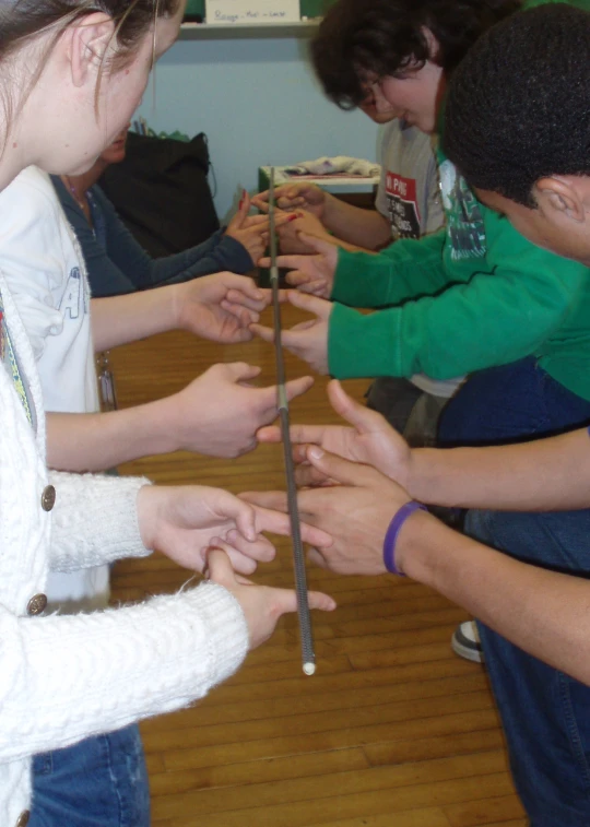 four people that are standing around pointing out numbers