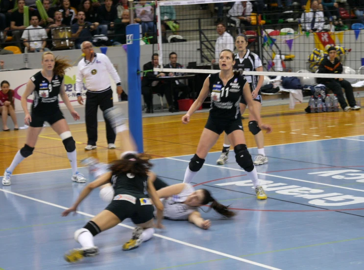 a group of women in uniform playing a game of volleyball