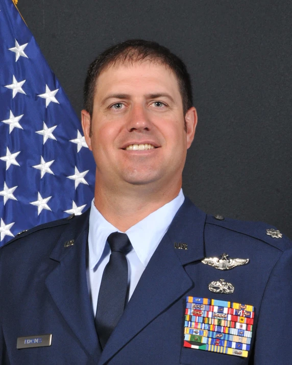 a man in military uniform in front of an american flag