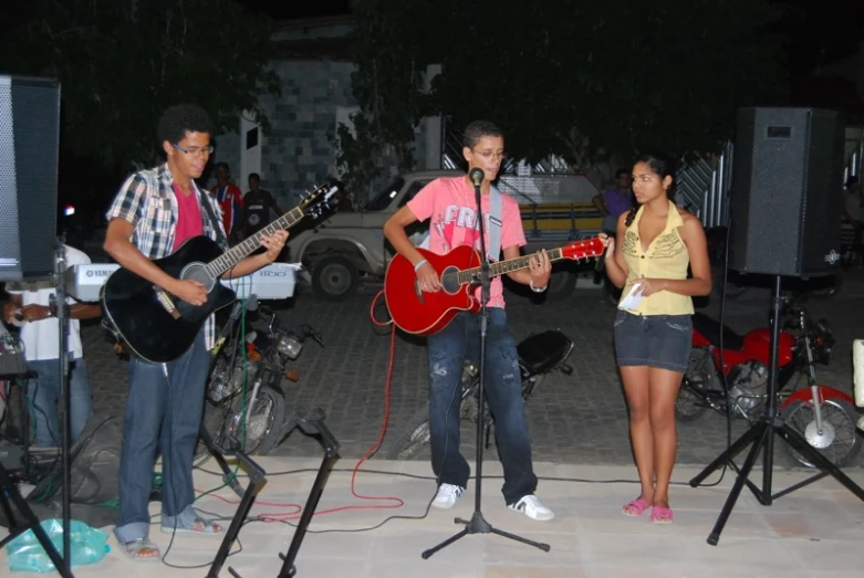 a group of people standing around and playing guitars