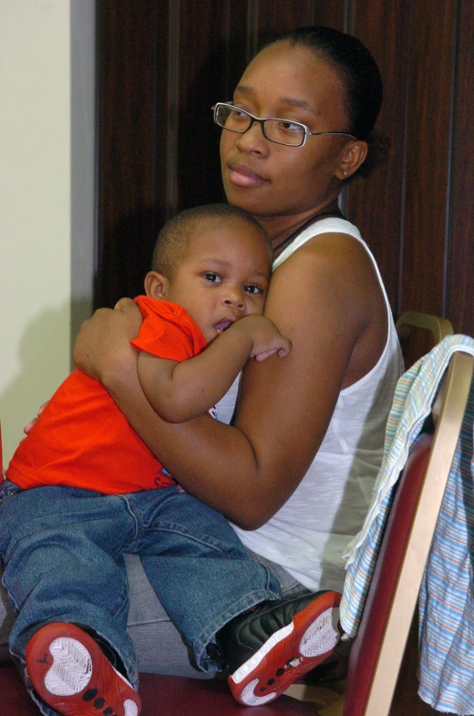 a woman holds her baby, who is holding the other