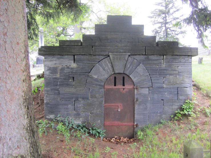 an old, broken outhouse sitting in the grass