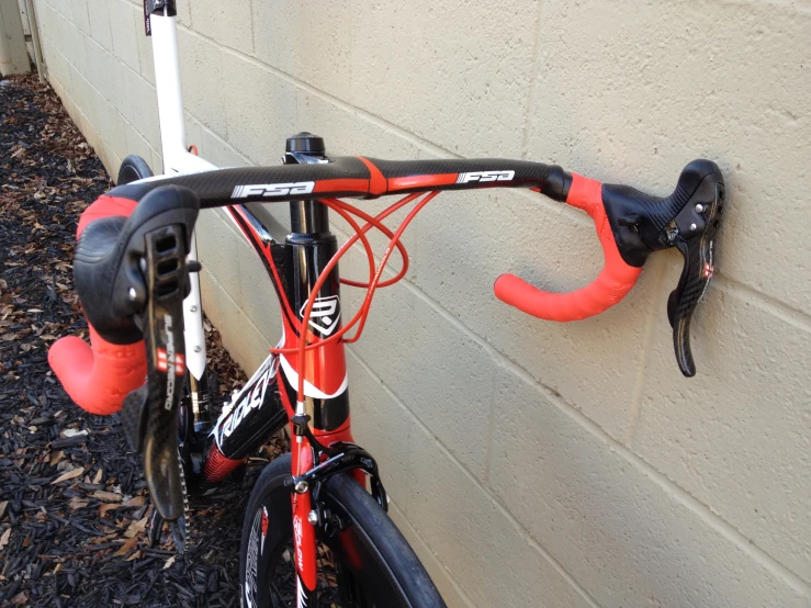 a bike parked by a building with red handles