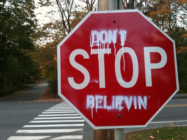 this is a stop sign with graffiti that says don't be belivin