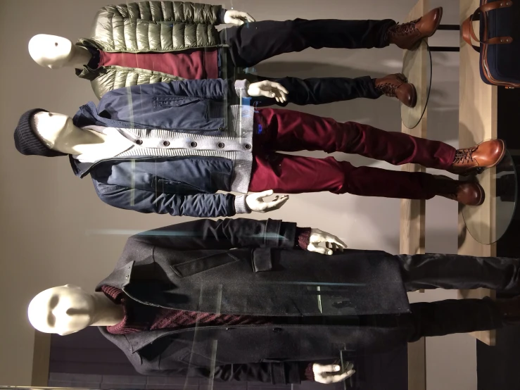 three mannequins in jackets and boots next to each other