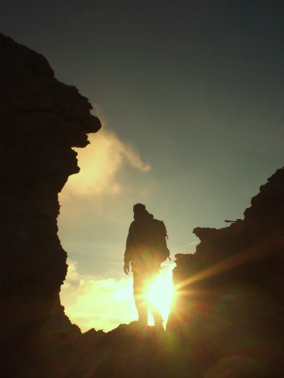 the sun is coming up behind some people and the rocks