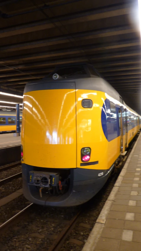 a yellow and gray train in a station