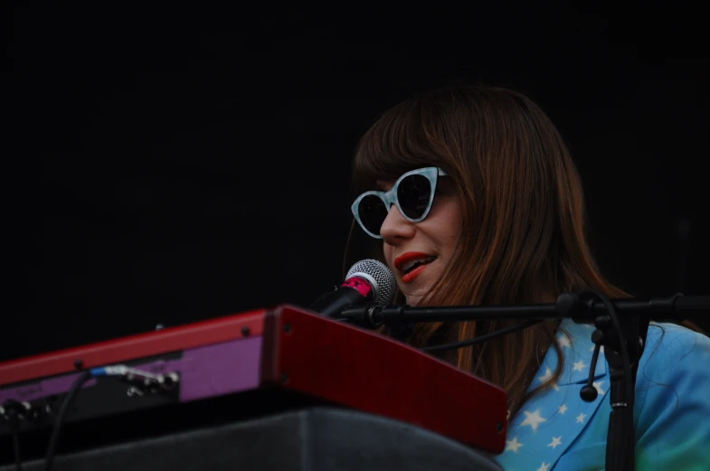 a woman with sun glasses standing at a podium