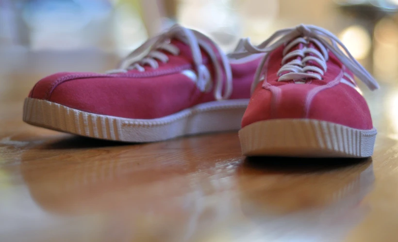 a red sneaker on top of a wooden table