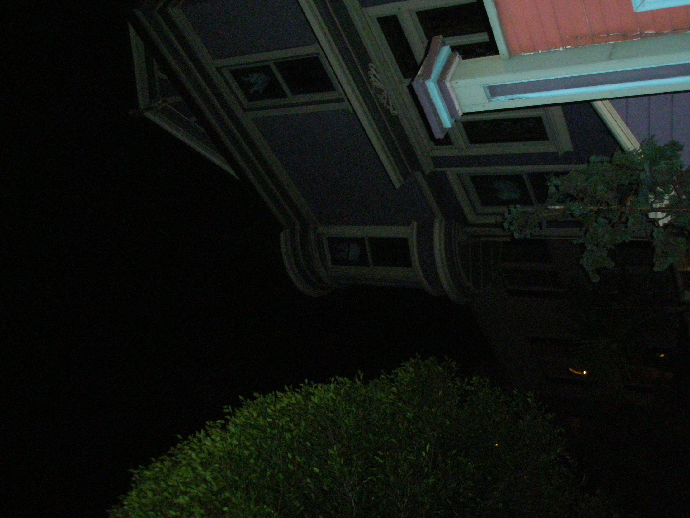 a street sign attached to a roof at night