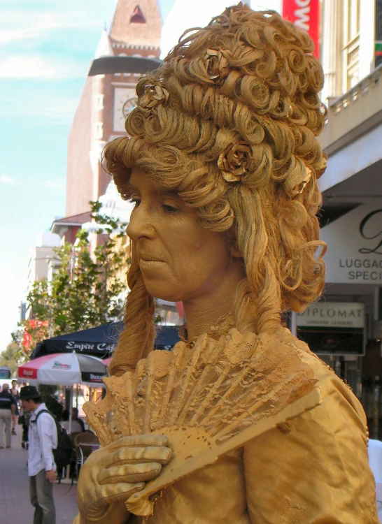 a sculpture of a woman wearing a tan dress