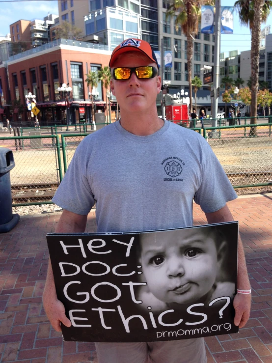 man holding protest sign while holding up a cardboard sign