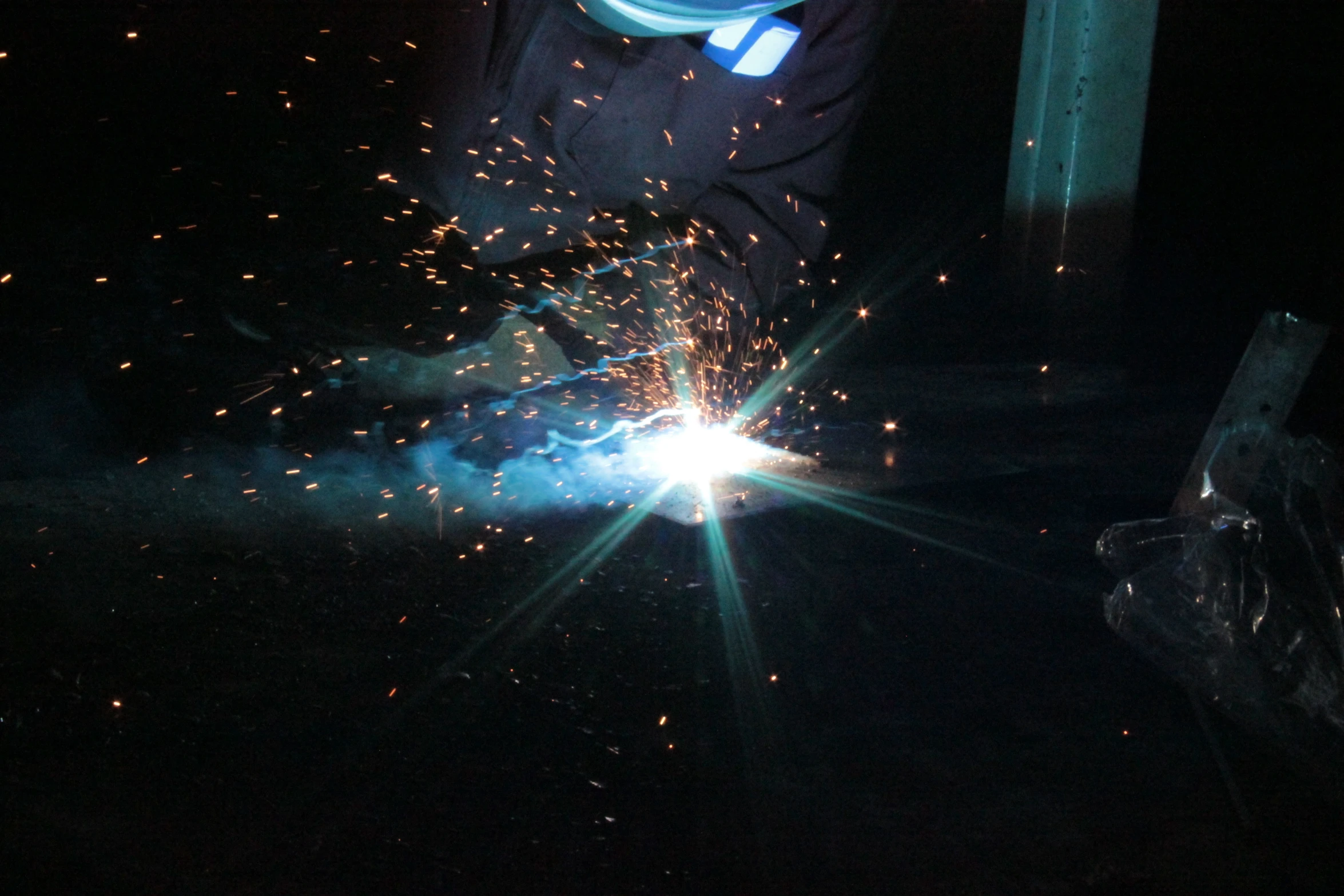 welder working with sparks in the dark at night