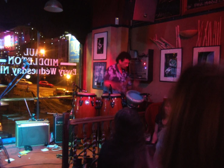 a man playing drums while others look on