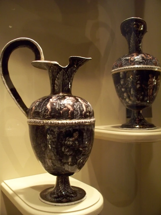 two artistic vases sitting on display in a glass case