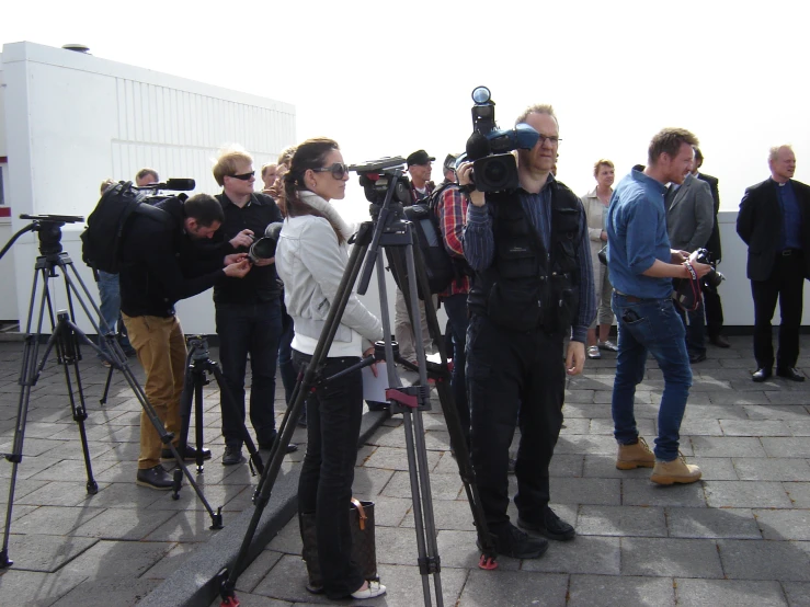 a group of people surrounding some cameras on a ledge