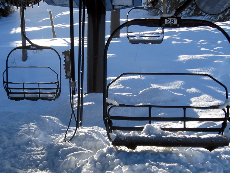 a snow covered ski lift at the bottom of the hill