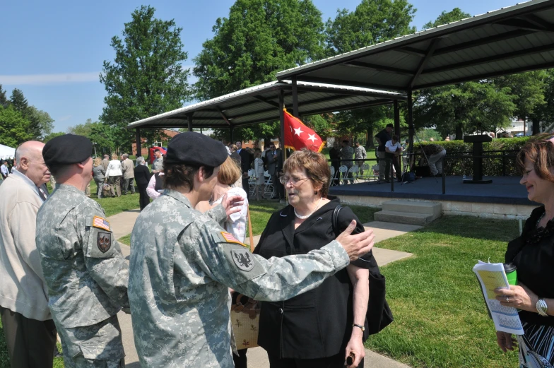 two women in military uniform talk with two men