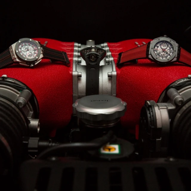a red case with two wristwatchs sits on the seat of a motorcycle