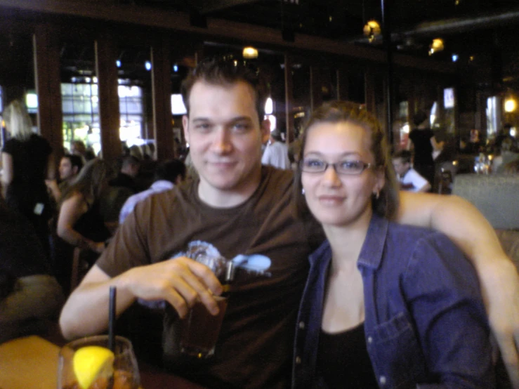 a man and woman are seated at a bar