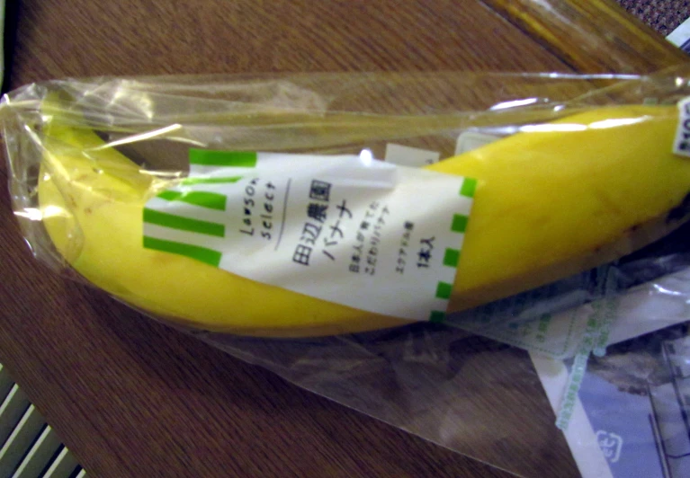 an apple and banana wrapped in plastic sitting on a table