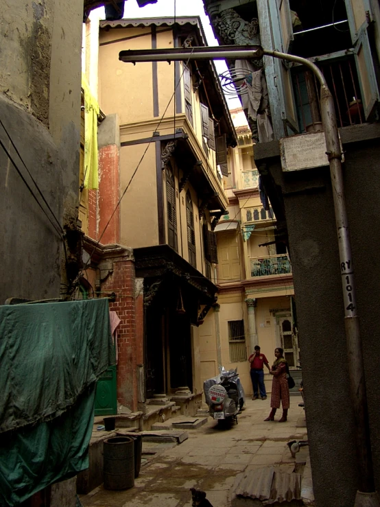 two children walking in an alleyway past buildings