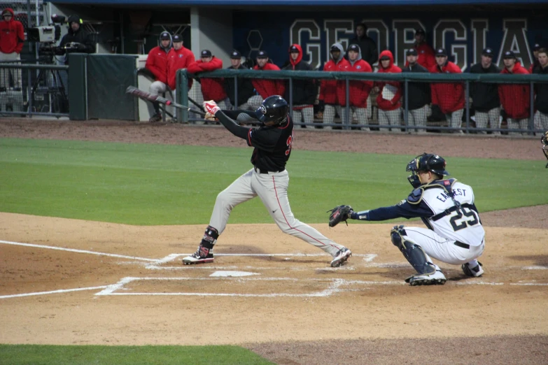 a baseball player swinging a bat over home plate