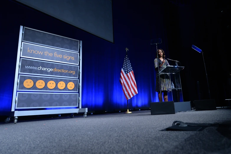 a woman is talking into a microphone while standing at a podium