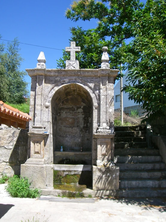 a stone gate and water trough surrounded by trees