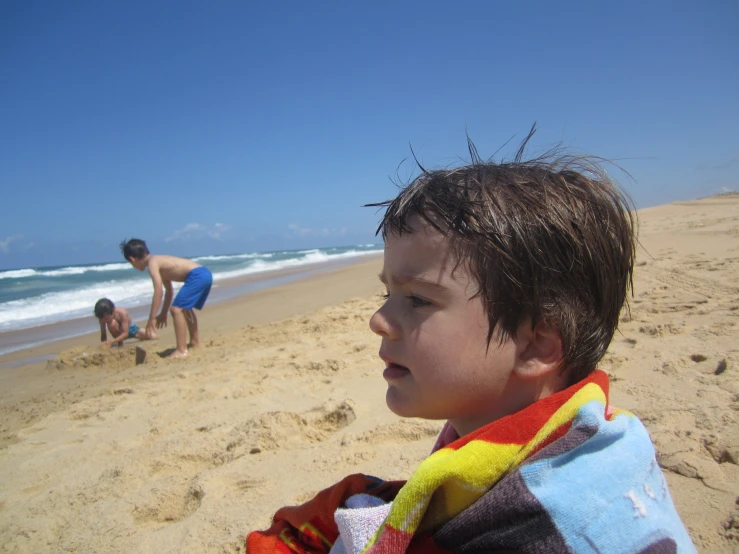 a small child in a bathrobe at the beach